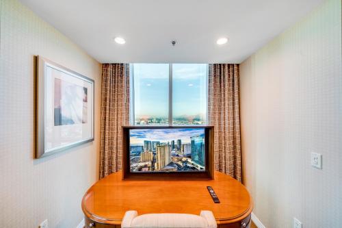 a television on a table in a room with a window at Jet Luxury at The Signature Condo Hotel in Las Vegas