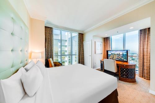 a bedroom with a large bed and a television at Jet Luxury at The Signature Condo Hotel in Las Vegas
