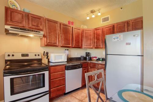 a kitchen with wooden cabinets and a white refrigerator at Gulf Shores Plantation Condos in Gulf Shores
