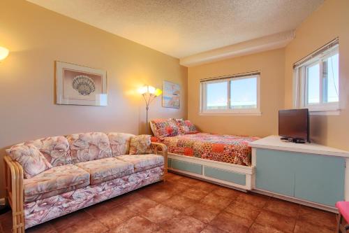 a living room with a couch and a tv at Gulf Shores Plantation Condos in Gulf Shores