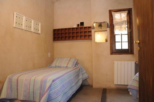 a small bedroom with a bed and a window at PUNTO Chacras.... in Chacras de Coria