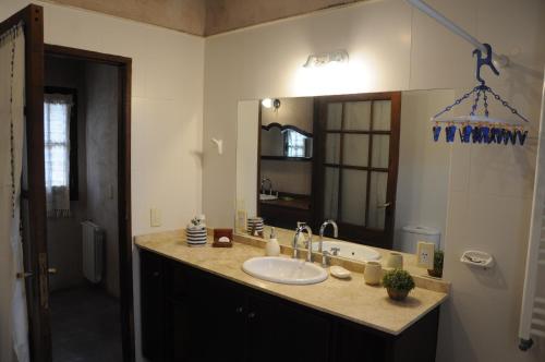 a bathroom with a sink and a large mirror at PUNTO Chacras.... in Chacras de Coria