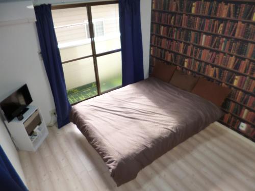 a small bed in a room with a large window at The Mickey Carlton Ohashi 207 in Fukuoka