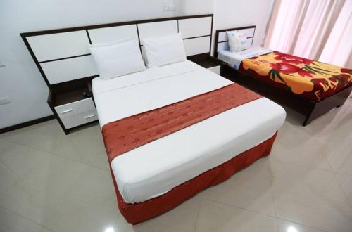 a bedroom with a large bed and a night stand at Posada Villa del Carmen in Catia La Mar