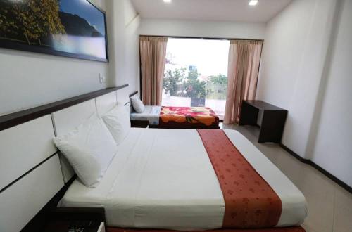 a hotel room with two beds and a window at Posada Villa del Carmen in Catia La Mar