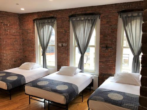 two beds sitting in a room with windows at Studios Midtown Manhattan in New York