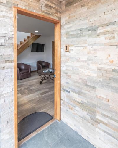 a door into a room with a brick wall at Etnias Apartments in Puerto Natales