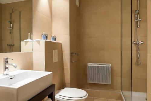 a bathroom with a toilet and a sink and a shower at Holiday Inn - Strasbourg - Nord by IHG in Schiltigheim