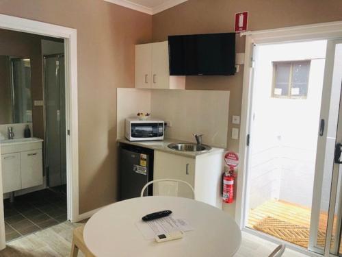 a kitchen with a white refrigerator and a white sink at Huskisson Beach Resort in Huskisson