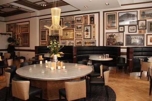 a restaurant with tables and chairs and pictures on the walls at Hotel Indigo - Edinburgh - Princes Street by IHG in Edinburgh
