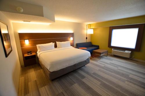 a hotel room with a bed and a flat screen tv at Holiday Inn Express Pittsburgh-Bridgeville by IHG in Bridgeville