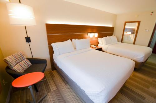 a hotel room with two beds and a red stool at Holiday Inn Express Pittsburgh-Bridgeville by IHG in Bridgeville