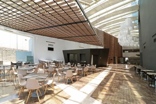 a dining room with tables and chairs and a fireplace at Holiday Inn Express San Luis Potosí by IHG in San Luis Potosí
