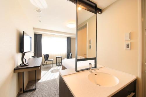 a bathroom with a sink and a large mirror at Richmond Hotel Yokohama Ekimae in Yokohama