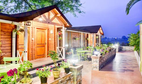 uma casa com um alpendre com vasos de plantas em Treebo Tryst Blue Mountain Country Club And Resort em Siliguri