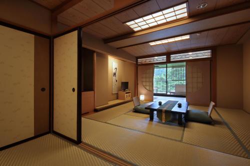 a room with a table and chairs and a window at Tsuganoki in Nikko