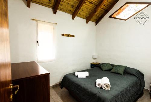 a bedroom with a bed with two towels on it at Cabaña Piedemonte in Lago Puelo