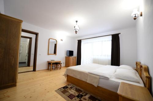 a bedroom with a bed and a large window at PENSIUNEA ARINAS in Vatra Dornei