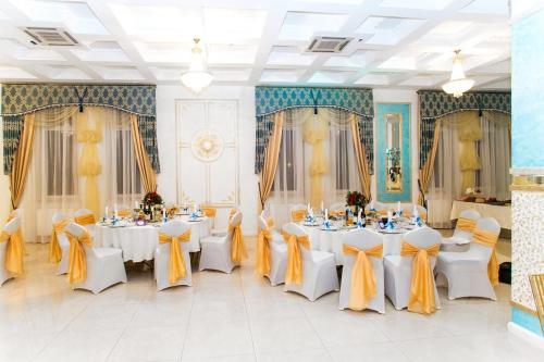 a banquet hall with white tables and yellow bows at Hotel Golden Night in Kaliningrad