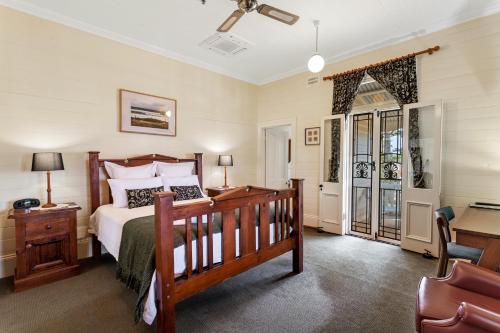 1 dormitorio con cama, escritorio y silla en Riversleigh House, en Ballina