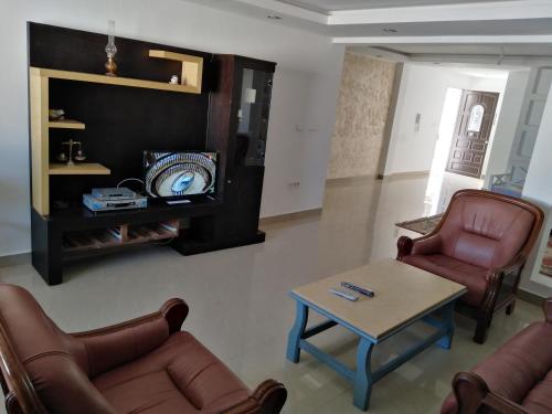a living room with couches and a table and a tv at Pretty and independent Apartment located in Tunis city in Tunis