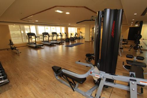 a gym with a bunch of treadmills and machines at Ivory Grand Hotel Apartments in Dubai