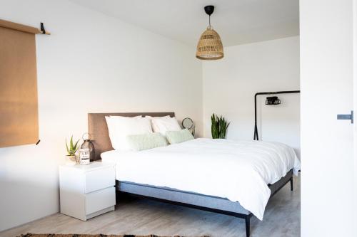 a bedroom with a bed and a pendant light at Studio Puuur in Zandvoort