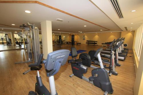 a gym with a bunch of treadmills and machines at Ivory Grand Hotel Apartments in Dubai