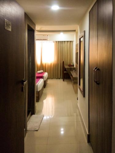 a corridor of a hotel room with a bedroom at Nexstay Crystal Residency in Kozhikode