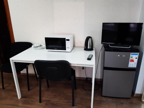 einen weißen Schreibtisch mit einer Mikrowelle und einem Computer darauf in der Unterkunft Hotel Admiral in Sankt Petersburg
