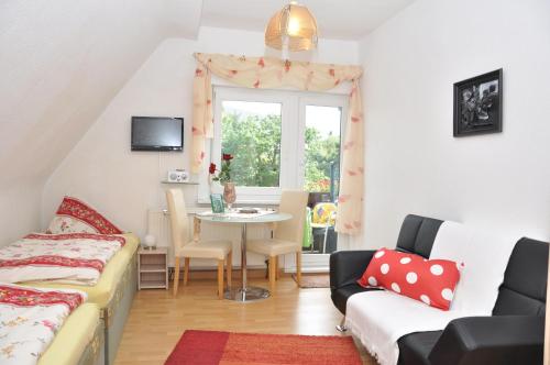 ein kleines Wohnzimmer mit einem Tisch und einem Fenster in der Unterkunft Pension Haus Barbara Oberhof in Oberhof