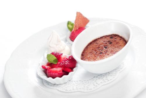 a cup of chocolate pudding and strawberries on a plate at Hotel Hirsch in Kehl am Rhein