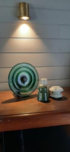 a wooden table with a lamp and a green at Fellcroft Farmstay in Cobaw