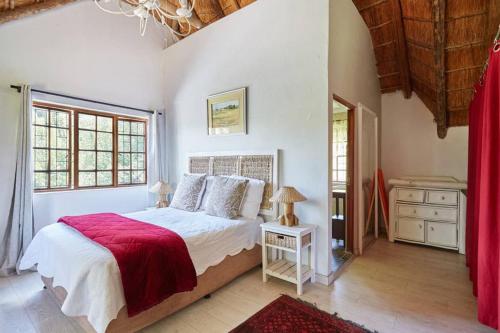 a bedroom with a large bed with a red blanket at 41 Ridge- self catering cottages in Midrand