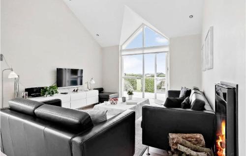 a living room with black leather furniture and a fireplace at 3 Bedroom Lovely Home In Hejls in Hejls