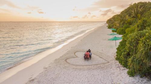 two people sitting in a heart on the beach at Sea View Villa Ukulhas in Ukulhas