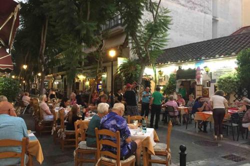 un groupe de personnes assises à table dans un restaurant dans l'établissement NICE APART LOS BOLICHES BEACH WIFI PARKING, à Fuengirola