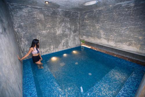 Eine Frau, die neben einem Schwimmbad steht. in der Unterkunft Sati Villa Kandy Sri Lanka in Kandy