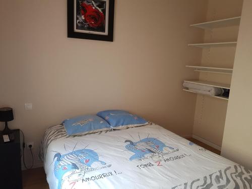 a bed in a room with blue pillows on it at Appart B tout confort, climatisé sur Coursan in Coursan