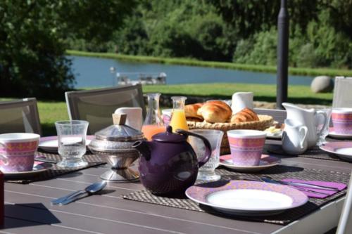 a picnic table with a table set with food and drinks at Les Vergnes in Saint-Pardoux-le-Neuf