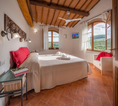 a bedroom with a large bed in a room with windows at Podere Felceto in Panzano