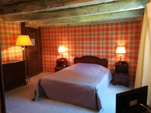 a bedroom with a bed and two lamps in it at Les Vergnes in Saint-Pardoux-le-Neuf