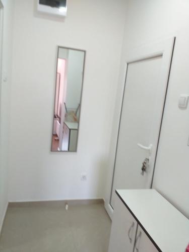a white bathroom with a mirror on the wall at Stan na dan in Loznica