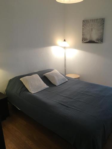 a bedroom with a blue bed with two pillows at Cabourg centre & plage in Cabourg