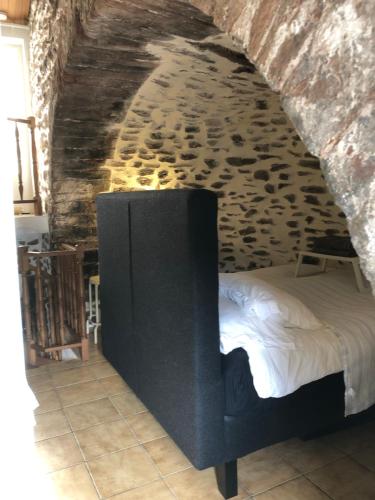 una camera con un letto in una parete in pietra di maison de vacances Médiévale Bormes-les-Mimosas village a Bormes-les-Mimosas