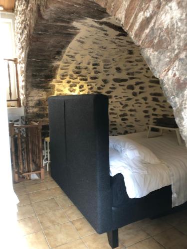une chambre avec un lit dans un mur de pierre dans l'établissement maison de vacances Médiévale Bormes-les-Mimosas village, à Bormes-les-Mimosas