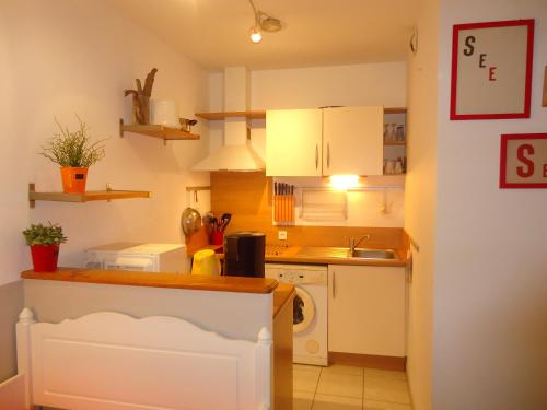 une petite cuisine avec des armoires blanches et un évier dans l'établissement Villa Pors Pol Carantec, à Carantec