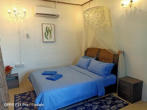 a bedroom with a bed with blue pillows on it at Senja Bay Resort in Perhentian Islands