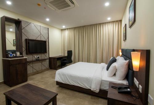 Habitación de hotel con cama y TV en Anna Residency The Quintessential Boutique Hotel en Pondicherry