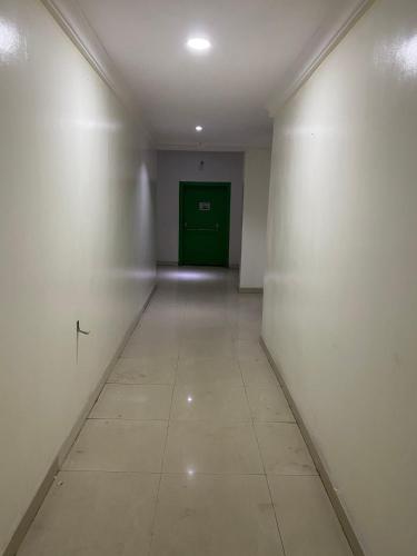 a hallway with a green door in a white wall at Posh Hotel and Suites Victoria Island in Lagos